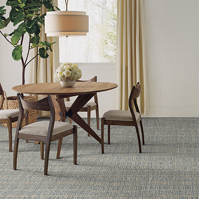 blue and grey pattern carpet in dining room with wood dining set